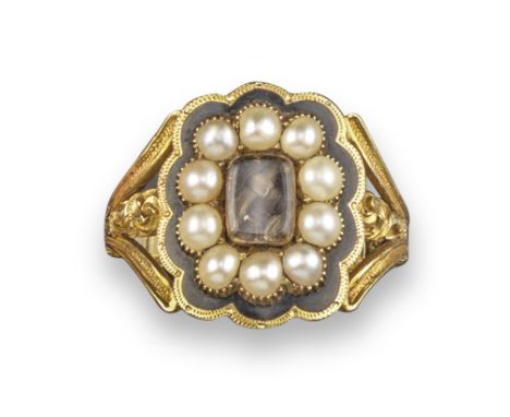 An early 19th century gold mourning ring, the central glazed locket compartment containing hair is set within a surround of s