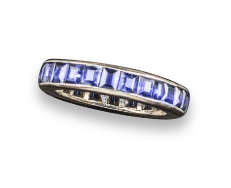 A sapphire full-circle eternity ring, the calibré-cut sapphires are channel-set in platinum, size N