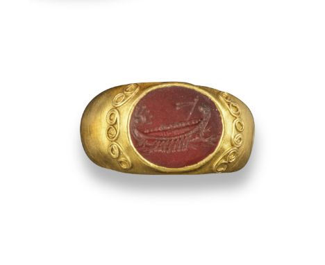 A carnelian intaglio depicting a gally, in the Roman style, in a gold ring with spiral Etruscan-style wirework decoration, in