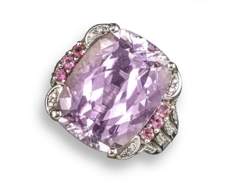 A kunzite and diamond cluster ring, set with a rectangular mixed-cut kunzite within a surround of circular-cut diamonds and k