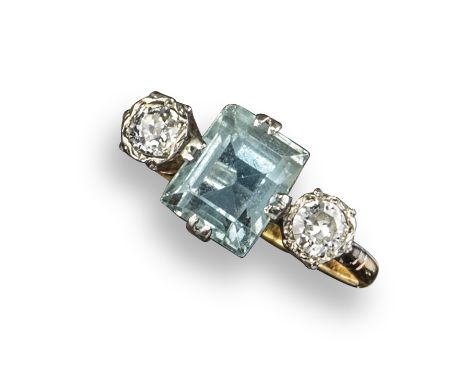 An aquamarine and diamond three stone ring, the rectangular aquamarine flanked with round brilliant-cut diamonds in platinum 