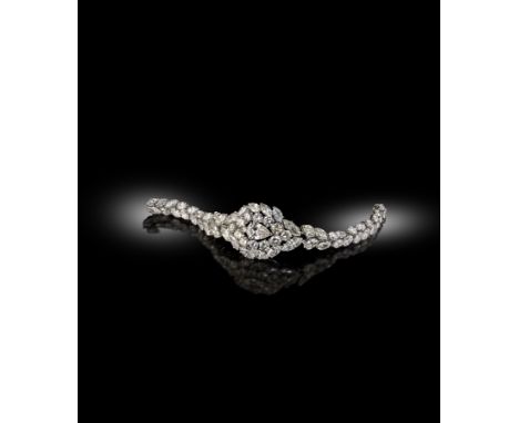 A diamond bracelet, centred with a pear-shaped diamond weighing 3.90cts and set within a surround of twelve round brilliant-c