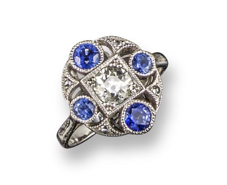 A sapphire and diamond cluster ring, of openwork quatrefoil design, centred with an old circular-cut diamond within a surroun