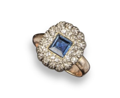 A sapphire and diamond cluster ring, the square-shaped sapphire is set within a surround of graduated old cushion-shaped diam