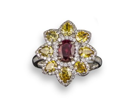 A ruby and fancy diamond cluster ring, of flowerhead design, centred with a cushion-shaped ruby within a surround of pear-sha