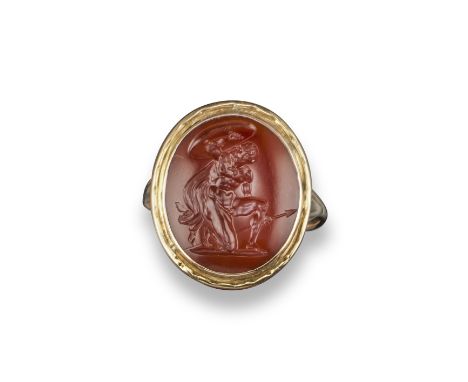 An early 19th century carnelian intaglio depicting a kneeling warrior, facing upwards and protecting his head with a sheild a