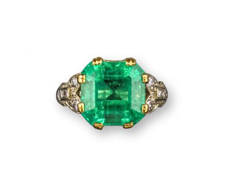 An emerald solitaire ring, set with an emerald-cut emerald weighing 6.85cts with circular-cut diamonds to the foliate shoulde