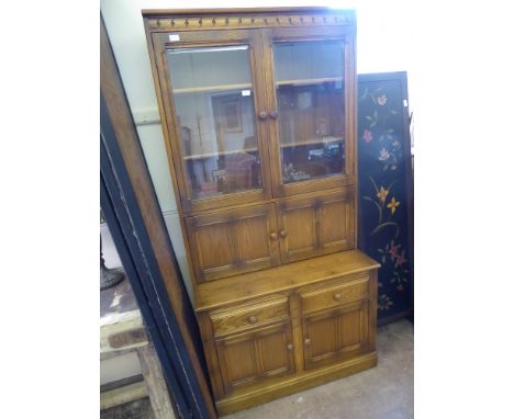 A Light Oak Ercol Glaze Fronted Dresser/Cupboard, with three shelves behind glaze fronted doors, four cutlery drawers with tw