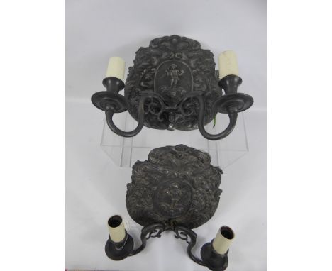 A Pair of Antique Twin Branch Light Sconces, lead effect decorated with cherubs and foliage.