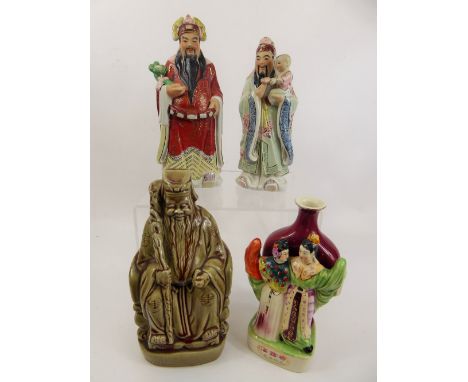 A Collection of Four Chinese Figurines, including wise man holding a walking stick, a man holding a young child, a robed figu