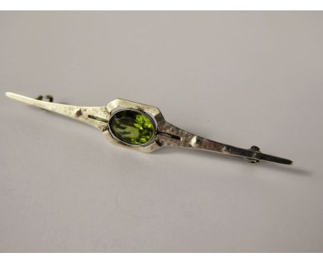 A Lady's Arts & Crafts Silver and Peridot Stick Brooch, the peridot approx 10 x 8 mm, approx 4.7 gms, 75 mm in length.