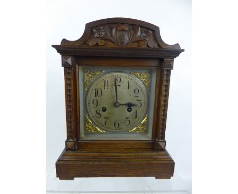 A Edwardian  Oak Cased Mantel Clock, with German Badische movement, the clock having a silvered face with numeric dial, brass