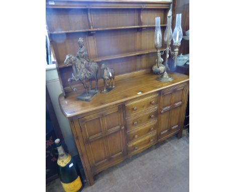 An Ercol Light Oak Dresser, with two plate shelves, four drawers and a cupboard to either side, approx 145 x 5 cms, very good