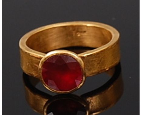 A high carat gold ruby solitaire ring, the round cut illusion set ruby weighing approx 1.5ct, 10.3g, band stamped 24k, size O