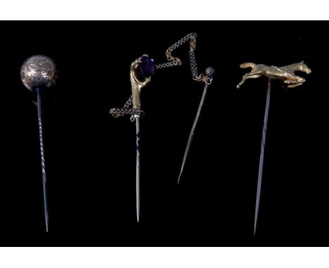 A yellow metal stick pin, modelled as a jumping horse, unmarked but tests as 18ct, on gilt metal pin; one other as an acanthu