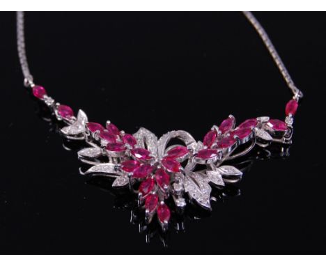 A contemporary 18ct white gold, ruby and diamond set necklet, the ribbon and flower setting arranged with marquise cut rubies
