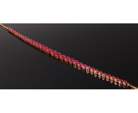 A modern ladies yellow metal and synthetic ruby set necklace, the metal apparently unmarked but tests as approx 18ct, the nec