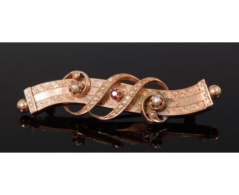 A yellow metal, ruby and seed pearl set brooch, unmarked but tests as approx 14ct, having engraved detail, 4.9g, 5cm 