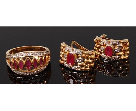 An 18ct gold, ruby and diamond set ring, arranged as seven graduated elliptical rubies flanked to either side with pavé set s