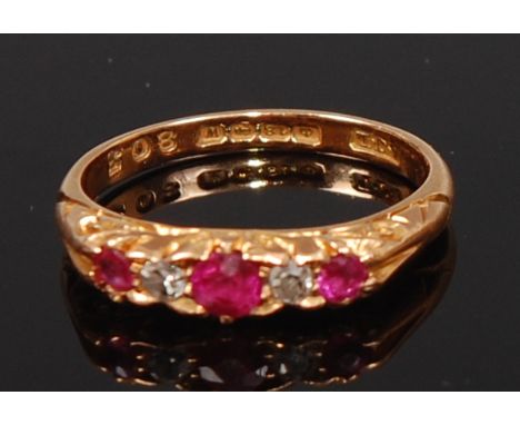 An 18ct gold, ruby and diamond dress ring, as three round cut rubies, each dispersed with a single small old cut diamond, 2.7