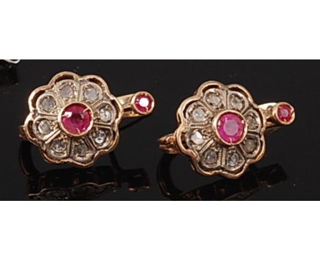 A pair of antique yellow metal, ruby and diamond set ear clips, each having centre illusion set round cut ruby in a surround 