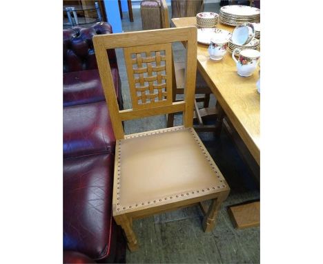 A set of four Robert 'Mouseman' Thompson lattice back oak dining chairs, with leather seat pads