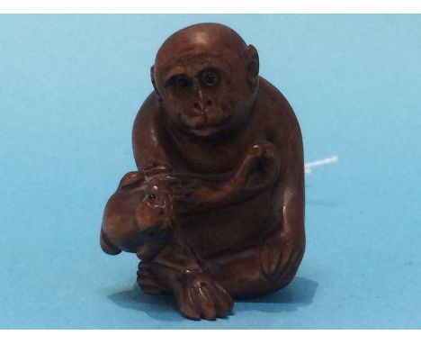 A carved netsuke in the form of a monkey and a frog
