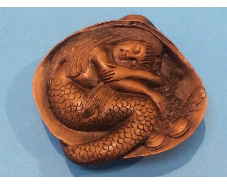 A carved netsuke in the form of a mermaid