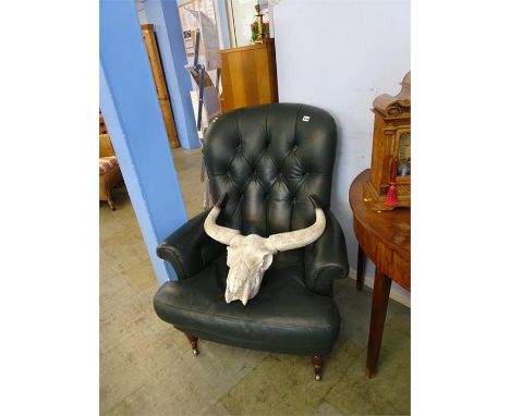 A green leather button back armchair