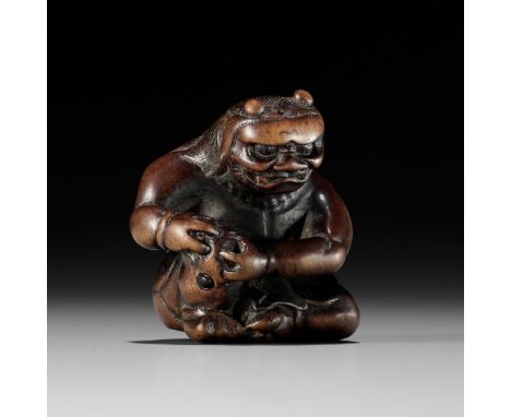 A POWERFUL WOOD NETSUKE OF AN ONI APPLYING MOXAUnsignedJapan, late 18th century, Edo period (1615-1868)Finely carved, the dem