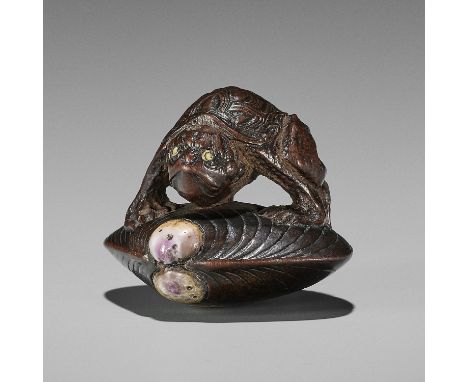 AN AMUSING INLAID WOOD NETSUKE OF A KAPPA ON HAMAGURI CLAMUnsigned  Japan, Edo (Tokyo), mid-19th century, Edo period (1615-18