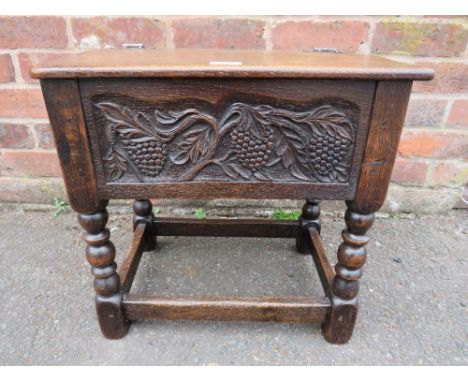 A SMALL CARVED OAK SEWING BOX RAISED ON BOBBIN TURNED SUPPORTS, H-46 W-48 CM