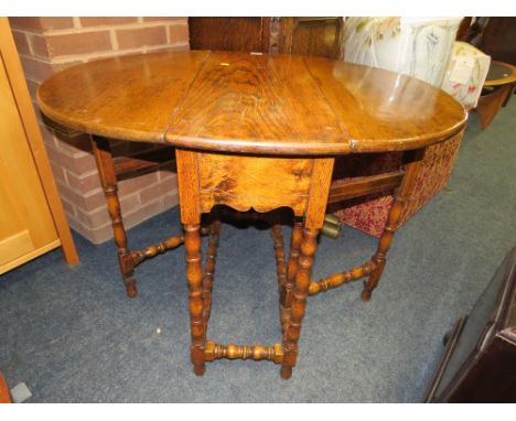 A SMALL ANTIQUE OAK DROPLEAF TABLE WITH BOBBIN TURNED SUPPORTS
