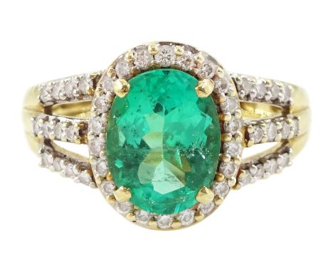 18ct gold single stone oval cut emerald and round brilliant cut diamond cluster ring, with diamond set shoulders by Iliana, h