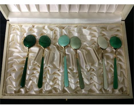 A boxed set of enamel and silver gilt coffee spoons