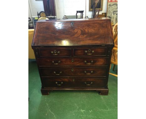 An early 19th Century Mahogany bureau, the interior fitted with a small central drawer, small drawers and pigeonholes, two sh