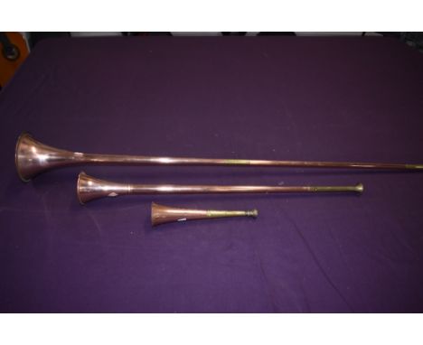 Three copper and brass hunting or post horns  varying sizes 22cm to 104cm