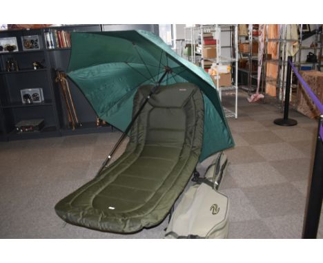An on the bank seat /camp-bed, by NGT Specimen along with a large fishing umbrella and a rod carry case