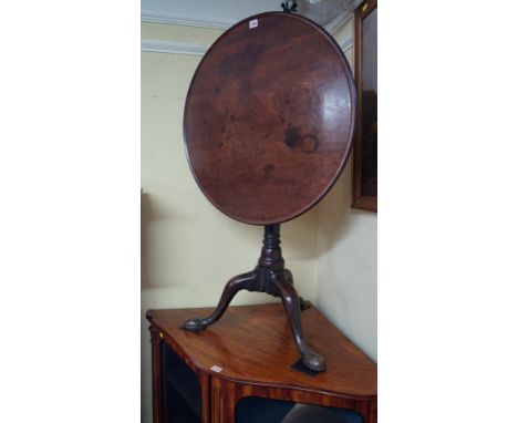 A George III mahogany tilt-top circular tripod table, the dished single piece top above a birdcage action, inverted baluster 