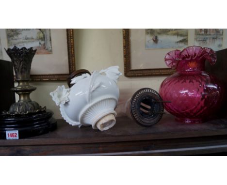 A Victorian brass and porcelain oil lamp, probably Moore Bros, (the cranberry shade a.f.).