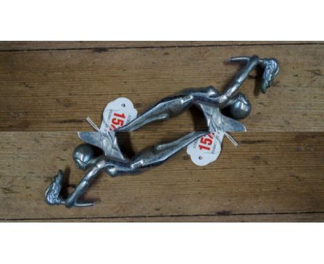 A vintage chrome car mascot, of a winged nude holding a flaming torch. 