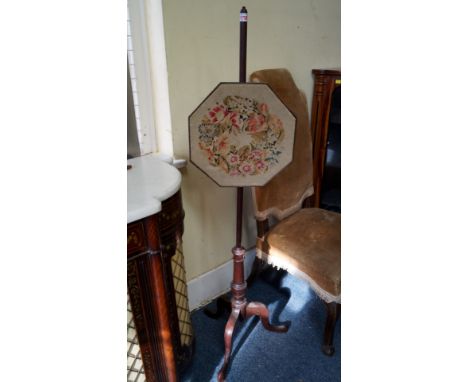 An old mahogany pole screen, with octagonal needlework panel and tripod base. 