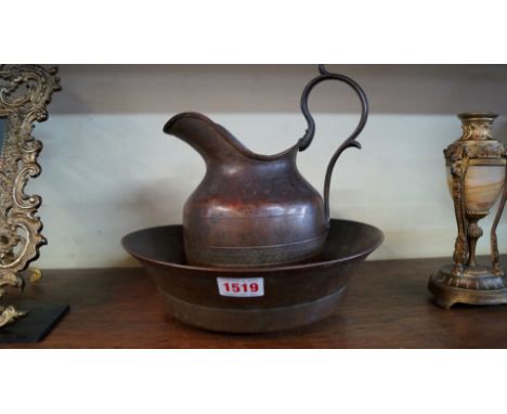 An early 19th century Russian patinated brass jug and basin, the basin 24.5cm diameter. 