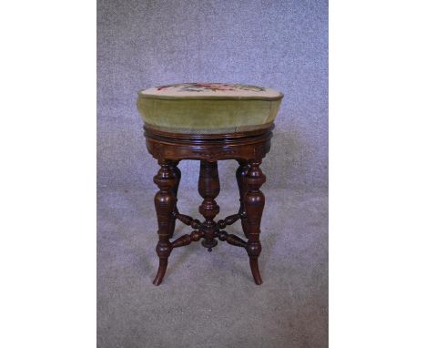 A Victorian walnut piano stool with adjustable tapestry upholstered seat. H.48 x 38cm 