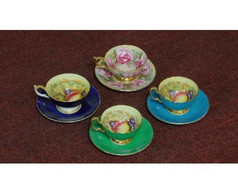 Four gilded Ainsley tea cups and saucers with fruit decoration along with one with rose flower motifs. 