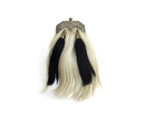 A white metal and horse hair sporran, early 20th century, with Celtic engraving and two metal bound black tassels, with red l
