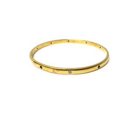 A gold, sapphire and diamond set circular bangle, mounted with circular cut diamonds alternating with circular cut sapphires,