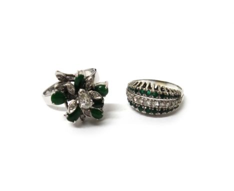 A diamond and emerald ring, mounted with a row of graduated circular cut diamonds to the centre and with a row of circular cu