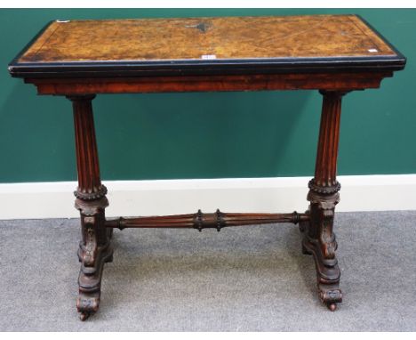 A Victorian burr walnut card table, the rectangular fold over top on a pair of fluted columns united by stretcher, on four sc