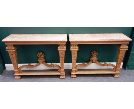 A pair of Louis XIV style console tables, each with faux painted marble tops over a carved bleached mahogany base, with taper